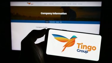 Stuttgart, Almanya - 06-18-2023: Tarım-fintech şirketi Tingo Group Inc. 'nin logosuna sahip akıllı telefon sahibi kişi web sitesinin önünde ekranda. Telefon ekranına odaklan.
