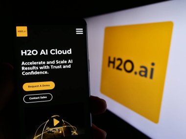 Stuttgart, Almanya - 06-18-2023: ABD 'li yapay zeka şirketi H2O.ai Inc.' in web sayfası ile birlikte cep telefonu tutan kişi logolu ekranda. Telefon ekranının merkezine odaklan.