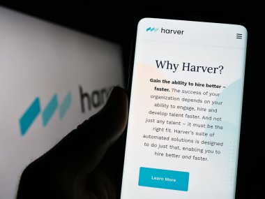 Stuttgart, Almanya - 06-18-2023: Yetenek yönetimi şirketi Harver B.V. 'nin internet sayfası olan cep telefonu logolu kişi ekranda. Telefon ekranının merkezine odaklan.
