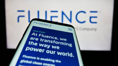 Stuttgart, Germany - 06-18-2023: Mobile phone with website of US company Fluence Energy LLC on screen in front of business logo. Focus on top-left of phone display. clipart