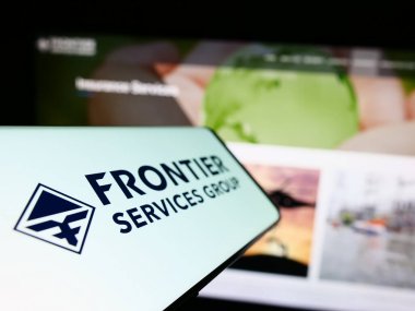 Stuttgart, Almanya - 06-19-2023: Ticari İnternet sitesi önünde üzerinde Sınır Hizmetleri Grubu Limited (FSG) logosu bulunan cep telefonu. Telefon ekranının soluna odaklan.