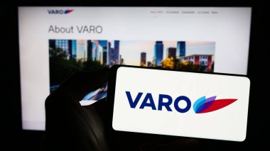 Stuttgart, Almanya - 06-19-2023: İsviçreli firma VARO Energy Marketing AG 'nin logosunu taşıyan cep telefonu sahibi şirket web sitesi önünde ekranda. Telefon ekranına odaklan.