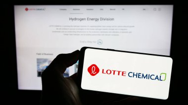 Stuttgart, Almanya - 06-19-2023: Koreli Lotte Chemical Corporation şirketinin logosuyla cep telefonu sahibi kişi iş sayfasının önünde ekranda. Telefon ekranına odaklan.