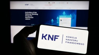 Stuttgart, Almanya - 06-19-2023: Komisja Nadzoru Finansowego (KNF) logosunun bulunduğu cep telefonu web sayfası önünde ekranda. Telefon ekranına odaklan.