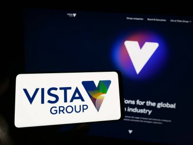 Stuttgart, Almanya - 06-23-2023: İnternet sitesi önünde Vista Group International Limited şirketinin logosuna sahip akıllı telefon sahibi kişi. Telefon ekranına odaklan.