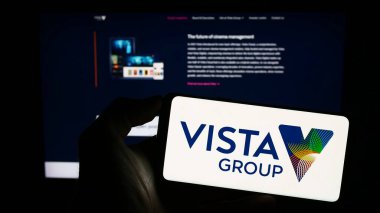 Stuttgart, Almanya - 06-23-2023: Vista Group International Limited şirketinin logosuyla cep telefonu sahibi kişi iş sayfasının önünde ekranda. Telefon ekranına odaklan.