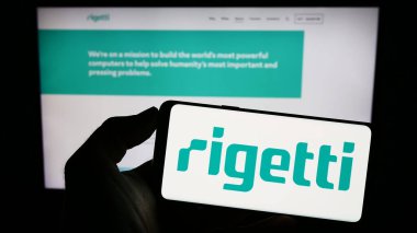 Stuttgart, Almanya - 06-24-2023: Amerikan Rigetti Computing Inc. şirketinin logosunun bulunduğu cep telefonu sahibi kişi iş sayfasının önünde ekranda. Telefon ekranına odaklan.