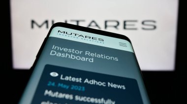 Stuttgart, Almanya - 06-24-2023: Alman yatırım şirketi Mutares SE Co. KGaA 'nın web sayfası ile birlikte cep telefonu logonun önünde ekranda. Telefon ekranının sol üst kısmına odaklan.