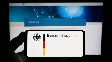 Stuttgart, Almanya - 06-24-2023: Alman yetkili Bundesnetzagentur (BNetzA) logosuna sahip kişi web sitesi önünde ekranda. Telefon ekranına odaklan.