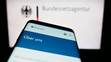 Stuttgart, Almanya - 06-24-2023: Alman yetkili Bundesnetzagentur (BNetzA) sitesinin bulunduğu cep telefonu logonun önünde ekranda. Telefon ekranının sol üst kısmına odaklan.