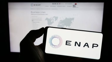 Stuttgart, Almanya - 06-24-2023: Web sayfasındaki ekranda Empresa Nacional del Petroleo (ENAP) şirketinin logosunun bulunduğu cep telefonu sahibi kişi. Telefon ekranına odaklan.