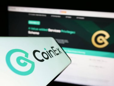 Stuttgart, Almanya - 06-24-2023: Şifreli döviz kurunun logosu olan cep telefonu, ticari web sitesi önünde ekranda CoinEx. Telefon ekranının merkez soluna odaklan.
