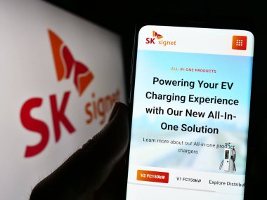 Stuttgart, Almanya - 06-24-2023: Koreli EV şarj şirketi SK Signet 'in web sayfası ile akıllı telefon sahibi kişi logo önünde ekranda. Telefon ekranının merkezine odaklan.
