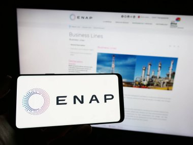 Stuttgart, Almanya - 06-24-2023: Web sayfası önünde ekranda Empresa Nacional del Petroleo (ENAP) şirketinin logosunun bulunduğu cep telefonu sahibi kişi. Telefon ekranına odaklan.