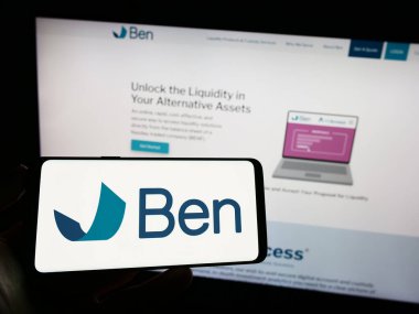 Stuttgart, Almanya - 06-24-2023: İş dünyası web sayfasının önünde üzerinde The Beneficient Company (Güvenilir Grup) logosu bulunan cep telefonu sahibi kişi. Telefon ekranına odaklan.