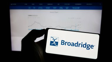 Stuttgart, Almanya - 06-24-2023: ABD 'li Broadridge Financial Solutions Inc. şirketinin logosunun bulunduğu cep telefonu web sayfası önünde ekranda. Telefon ekranına odaklan.