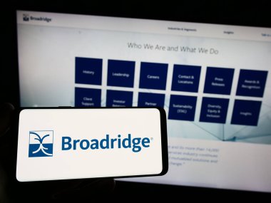 Stuttgart, Almanya - 06-24-2023: ABD 'li Broadridge Financial Solutions Inc.' in logosunu taşıyan kişi web sitesinin önünde ekranda. Telefon ekranına odaklan.