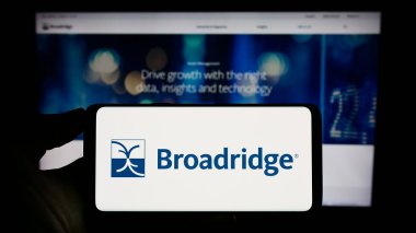 Stuttgart, Almanya - 06-24-2023: ABD 'li Broadridge Financial Solutions Inc. şirketinin logosunun bulunduğu cep telefonu web sayfası önünde ekranda. Telefon ekranına odaklan.