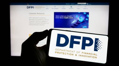 Stuttgart, Almanya - 04-23-2023: California DFPI logosu web sayfasının önünde olan cep telefonu sahibi kişi. Telefon ekranına odaklan.