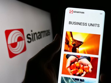 Stuttgart, Almanya - 04-23-2023: Endonezya holdingi Sinar Mas Group 'un web sayfası olan cep telefonu logosu önünde ekranda. Telefon ekranının merkezine odaklan.