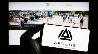 Stuttgart, Almanya - 04-23-2023: Fransız savunma şirketi Arquus SAS 'ın logosuyla cep telefonu sahibi kişi iş sayfasının önünde ekranda. Telefon ekranına odaklan.