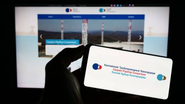 Stuttgart, Almanya - 04-25-2023: Caspian Pipeline Consortium (CPC) logosu olan cep telefonu sahibi kişi iş sayfası önünde ekranda. Telefon ekranına odaklan.