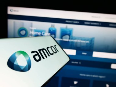 Stuttgart, Almanya - 04-27-2023: Amcor plc ambalaj şirketinin logosuna sahip akıllı telefon iş sitesinin önünde ekranda. Telefon ekranının merkezine odaklan.