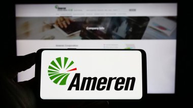 Stuttgart, Almanya - 04-27-2023: ABD 'li enerji şirketi Ameren Corporation' ın logosuyla cep telefonu sahibi kişi iş sayfasının önünde ekranda. Telefon ekranına odaklan.