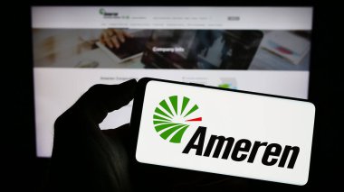 Stuttgart, Almanya - 04-27-2023: ABD 'li enerji şirketi Ameren Corporation' ın logosunu elinde tutan kişi web sitesinin önünde ekranda. Telefon ekranına odaklan.