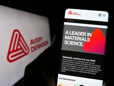 Stuttgart, Almanya - 04-28-2023: ABD 'li ambalaj şirketi Avery Dennison Corporation' ın web sayfası ve logosu olan kişi. Telefon ekranının merkezine odaklan.