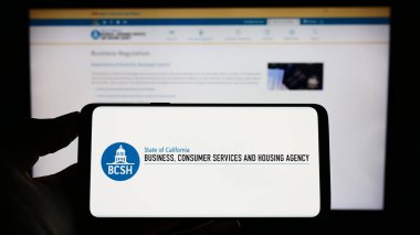 Stuttgart, Almanya - 04-28-2023: İş logosu, Tüketici Hizmetleri ve Konut Hizmetleri 'nin yer aldığı cep telefonu web sayfası önünde ekranda. Telefon ekranına odaklan.