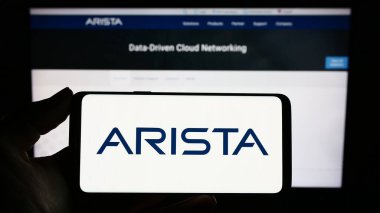 Stuttgart, Almanya - 04-28-2023: Web sayfası önünde ekranda bilgisayar ağı şirketi Arista Networks Inc. 'in logosuna sahip cep telefonu tutan kişi. Telefon ekranına odaklan.