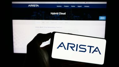 Stuttgart, Almanya - 04-28-2023: İnternet sayfası önünde bilgisayar ağı şirketi Arista Networks Inc. 'in logosuna sahip cep telefonu sahibi kişi. Telefon ekranına odaklan.
