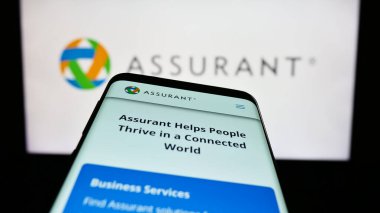 Stuttgart, Almanya - 04-28-2023: İş logosu önünde ABD sigorta şirketi Assurant Inc. 'in web sitesine sahip akıllı telefon. Telefon ekranının sol üst kısmına odaklan.