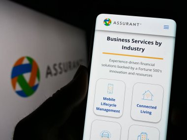 Stuttgart, Almanya - 04-28-2023: ABD 'li sigorta şirketi Assurant Inc.' in web sayfası olan cep telefonu logosu önünde ekranda. Telefon ekranının merkezine odaklan.
