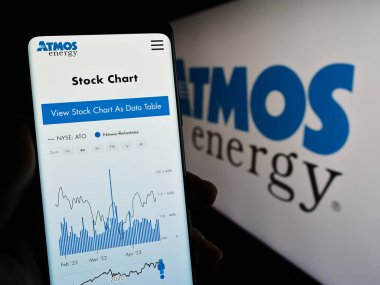 Stuttgart, Almanya - 04-28-2023: ABD 'li doğalgaz şirketi Atmos Energy Corporation' ın web sayfası ve logosu olan kişi. Telefon ekranının merkezine odaklan.