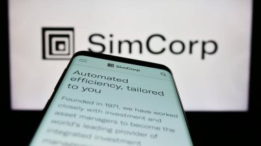 Stuttgart, Almanya - 04-28-2023: Danimarkalı finans yazılım şirketi SimCorp AS 'in web sayfası ile birlikte ticari logonun önünde. Telefon ekranının sol üst kısmına odaklan.