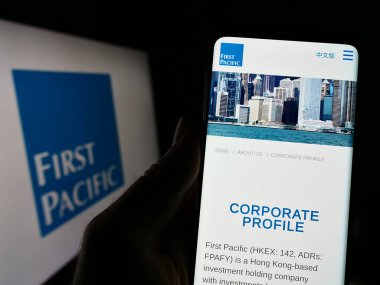 Stuttgart, Almanya - 04-28-2023: Yatırım şirketi First Pacific Limited 'in internet sayfası olan cep telefonu logolu kişi. Telefon ekranının merkezine odaklan.