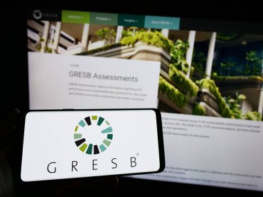 Stuttgart, Almanya - 04-28-2023: Hollandalı gayrimenkul vakfı ESG 'nin logosuna sahip akıllı telefon sahibi kişi web sitesinin önünde ekranda. Telefon ekranına odaklan.