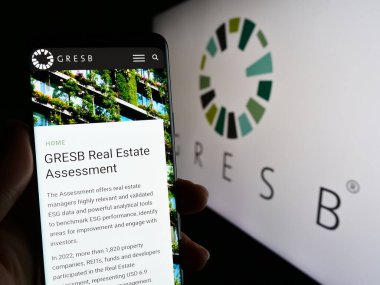 Stuttgart, Almanya - 04-28-2023: Hollandalı gayrimenkul vakfı ESG vakfı GRESB B.V. 'nin web sayfasını elinde tutan kişi logolu ekranda. Telefon ekranının merkezine odaklan.