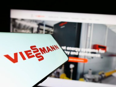 Stuttgart, Germany - 04-28-2023: Mobile phone with logo of German company Viessmann Group GmbH Co. KG on screen in front of business website. Focus on center of phone display. clipart