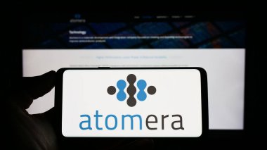 Stuttgart, Almanya - 06-16-2024: ABD 'li yarı iletken şirket Atomera Inc.' in logosuyla cep telefonu sahibi kişi iş sayfasının önünde ekranda. Telefon ekranına odaklan.