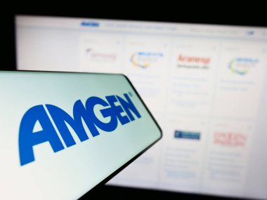 Stuttgart, Almanya - 06-17-2023: Sitenin önünde ekranda Amerikan biyofarmasötik şirketi Amgen Inc. 'in logosu bulunan cep telefonu. Telefon ekranının merkez soluna odaklan.