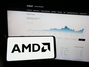 Stuttgart, Almanya - 06-17-2023: Web sayfası önünde üzerinde Advanced Micro Cihazlar A.Ş. (AMD) logosu bulunan cep telefonu sahibi kişi. Telefon ekranına odaklan.