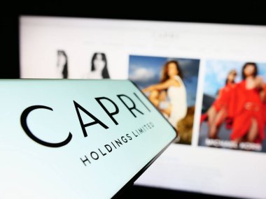 Stuttgart, Almanya - 06-17-2023: Moda şirketi Capri Holding Limited 'in logosuna sahip cep telefonu iş sitesinin önünde ekranda. Telefon ekranının merkez soluna odaklan.