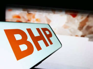 Stuttgart, Almanya - 06-17-2023: Avustralyalı maden şirketi BHP Group Limited 'in logosuna sahip cep telefonu iş sitesinin önünde ekranda. Telefon ekranının merkez soluna odaklan.