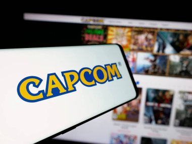 Stuttgart, Almanya - 01-03-2024: Japon video oyunları şirketi Capcom Co. Ltd. nin logosuna sahip akıllı telefon iş sitesinin önünde ekranda. Telefon ekranının soluna odaklan.