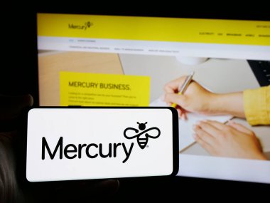 Stuttgart, Almanya - 01-03-2024: Yeni Zelanda enerji şirketi Mercury NZ Limited 'in logosuna sahip akıllı telefon sahibi kişi web sitesinin önünde ekranda görülüyor. Telefon ekranına odaklan.