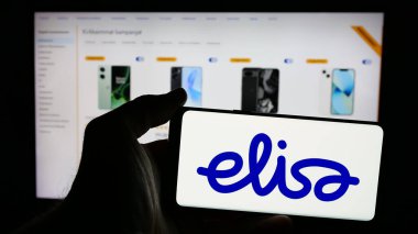 Stuttgart, Almanya - 01-03-2024: İnternet sayfasının önünde ekranda Fin telekomünikasyon şirketi Elisa Oyj 'un logosunun bulunduğu cep telefonu sahibi kişi. Telefon ekranına odaklan.