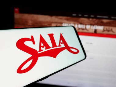 Stuttgart, Germany - 01-07-2024: Mobile phone with logo of American trucking company Saia Inc. on screen in front of business website. Focus on center-left of phone display. clipart